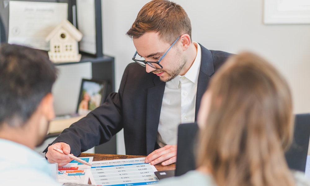 Real estate agent sitting across from his clients