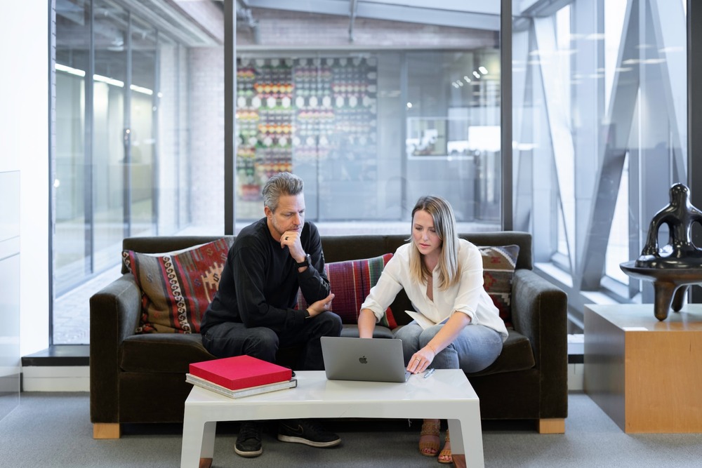 Two agents running through their real estate SERP and SEO metric on a computer