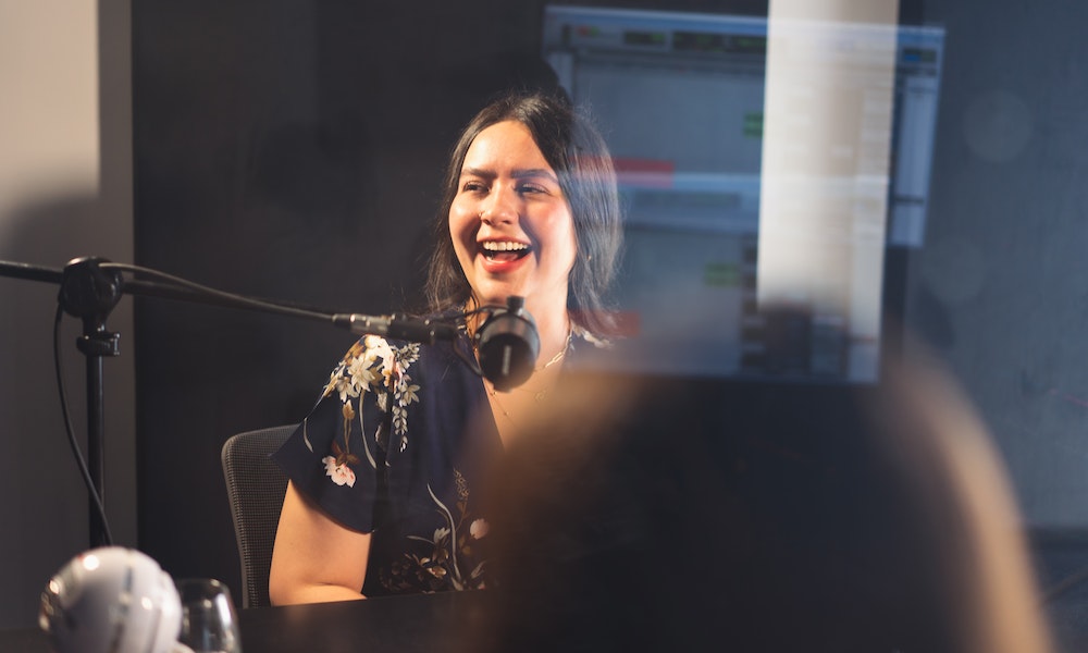 A real estate agent recording in a podcast booth