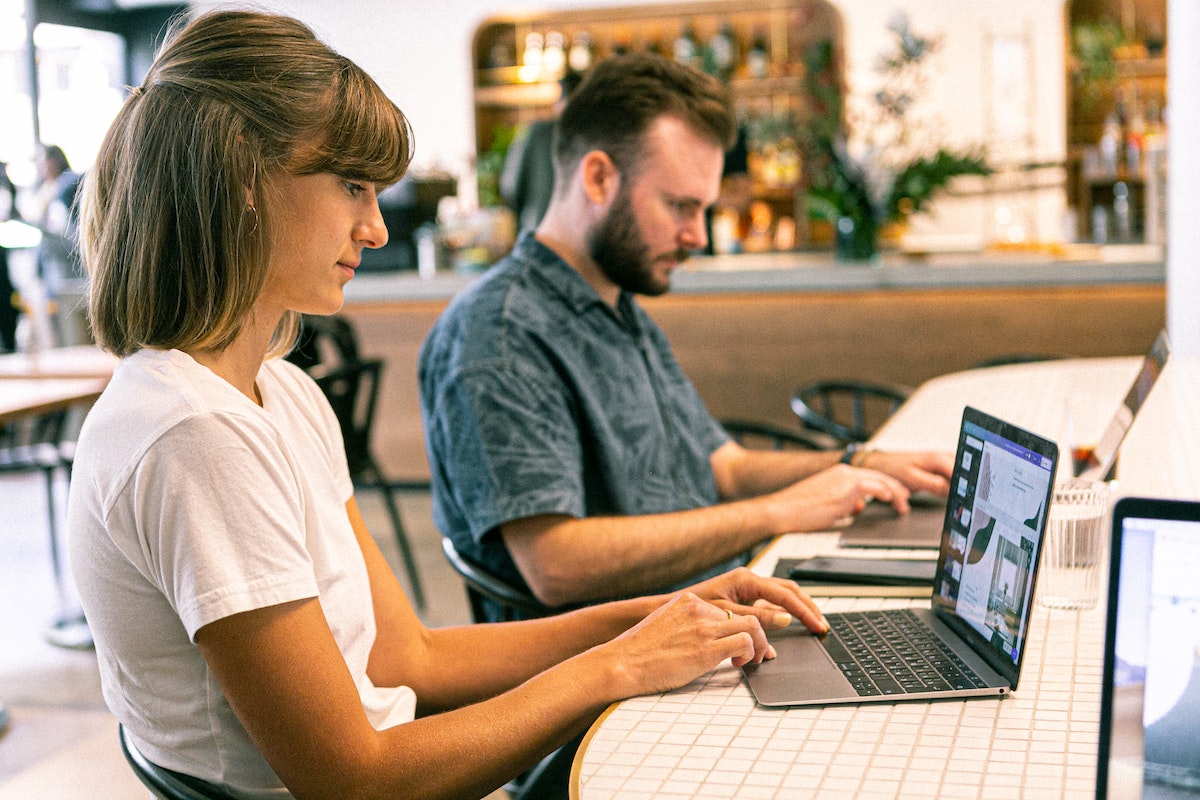 Man and woman using the marketing features of real estate CRM software.