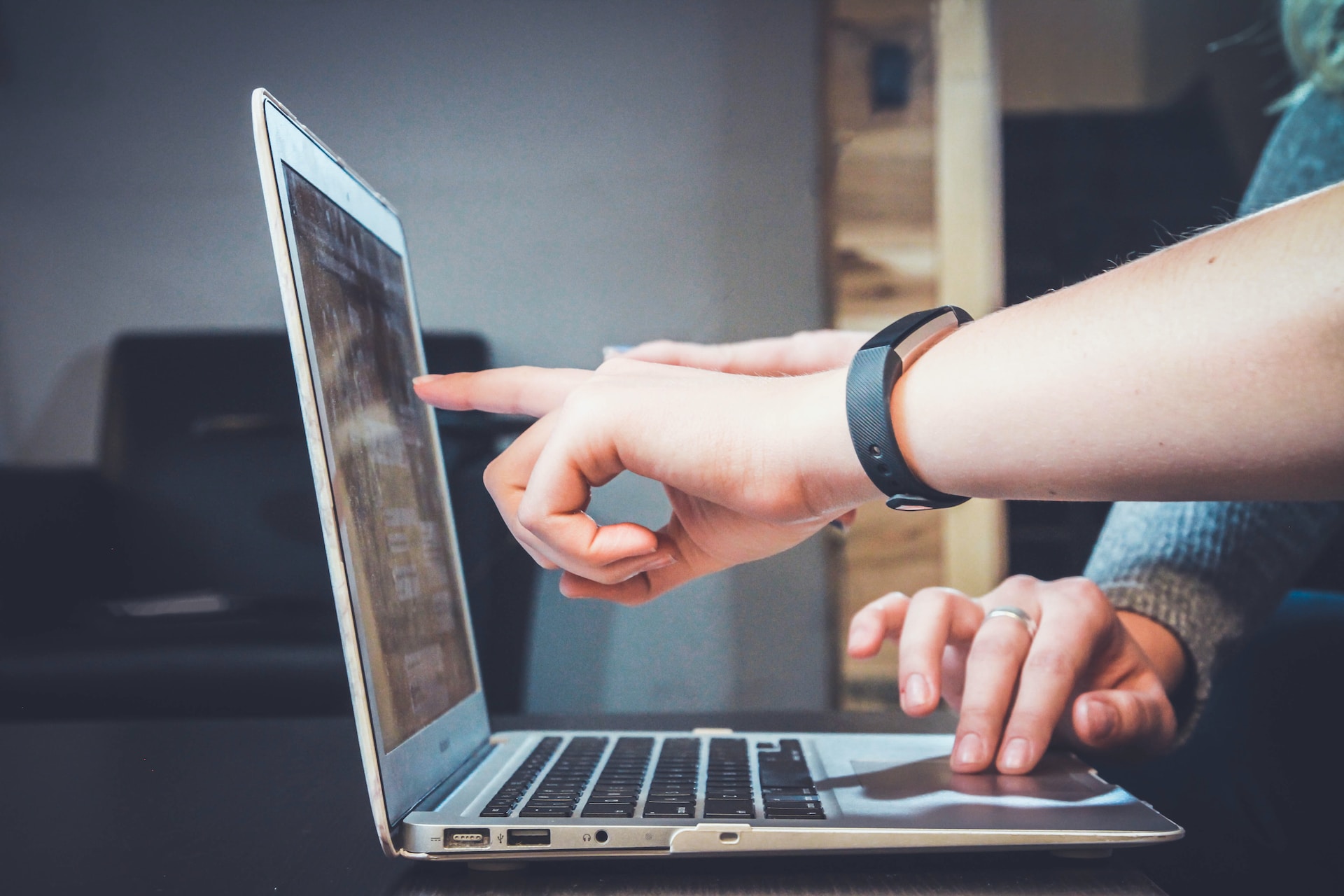 Real estate agents pointing to a screen.