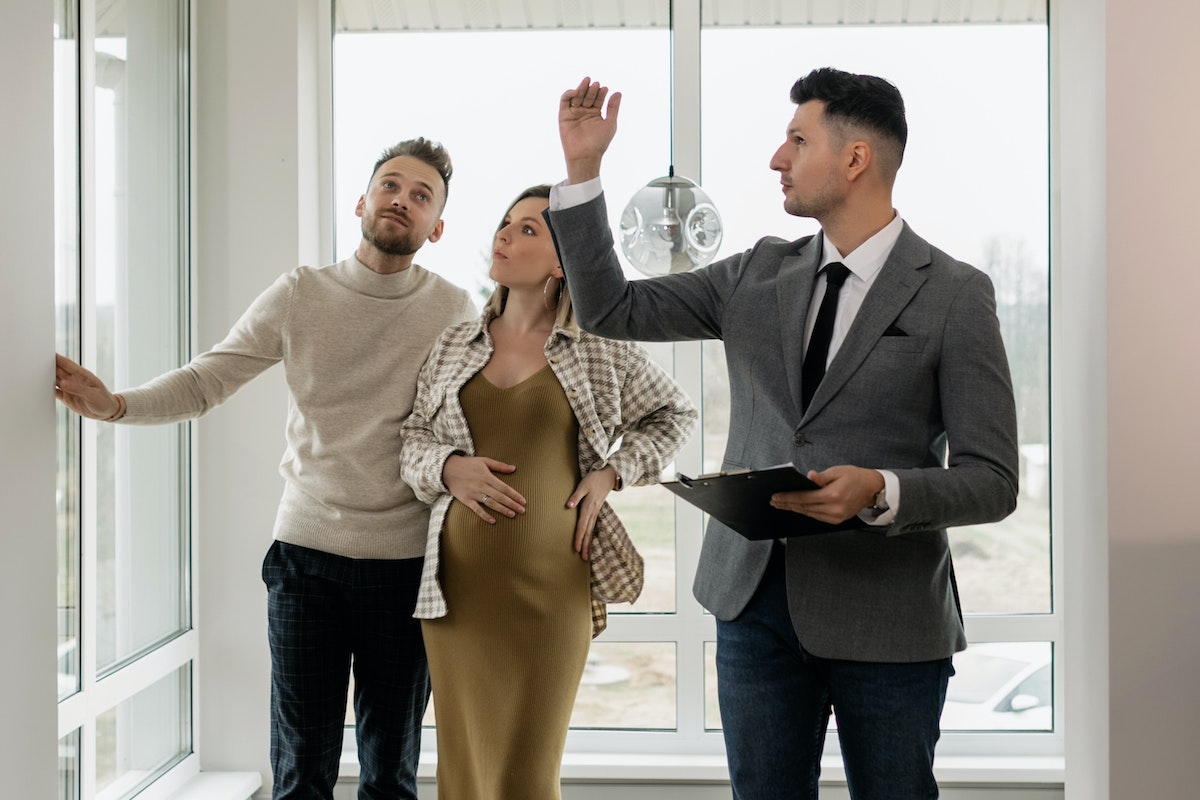 Real estate professional giving couple a tour of a house.