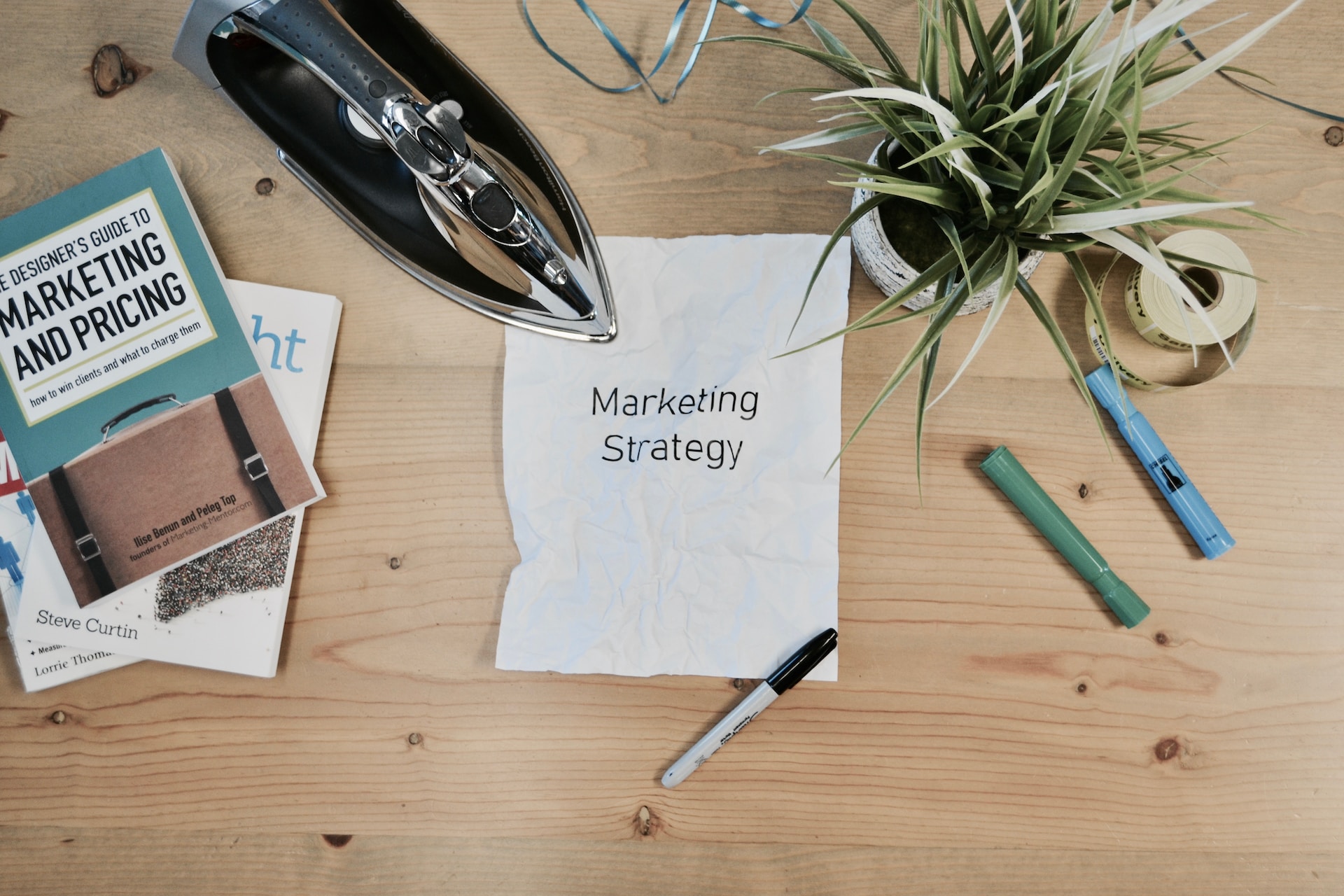 An iron pressing a paper with 'marketing strategy' on it.