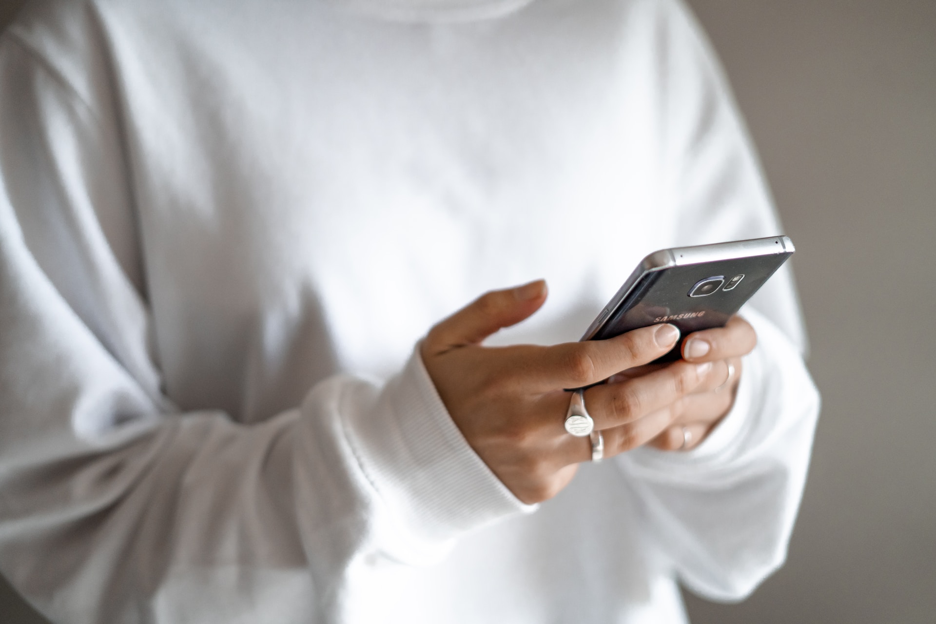 Woman using cell phone and responding to well-implemented real estate marketing ideas.