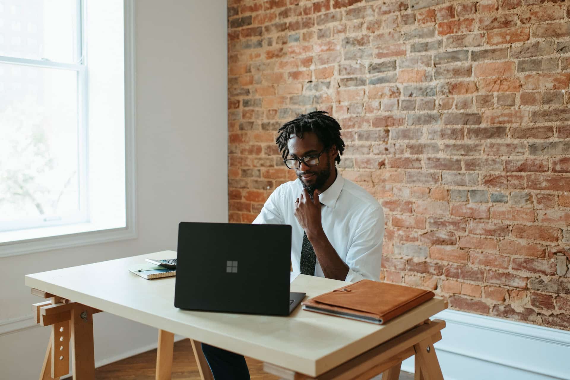 Estate agent sitting at a desk in front of his laptop.