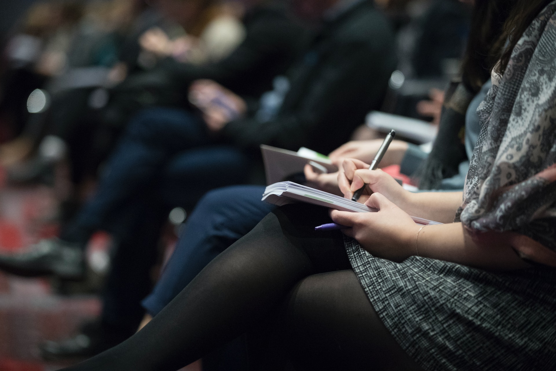 Aspiring agents taking notes in a structured real estate coaching program.