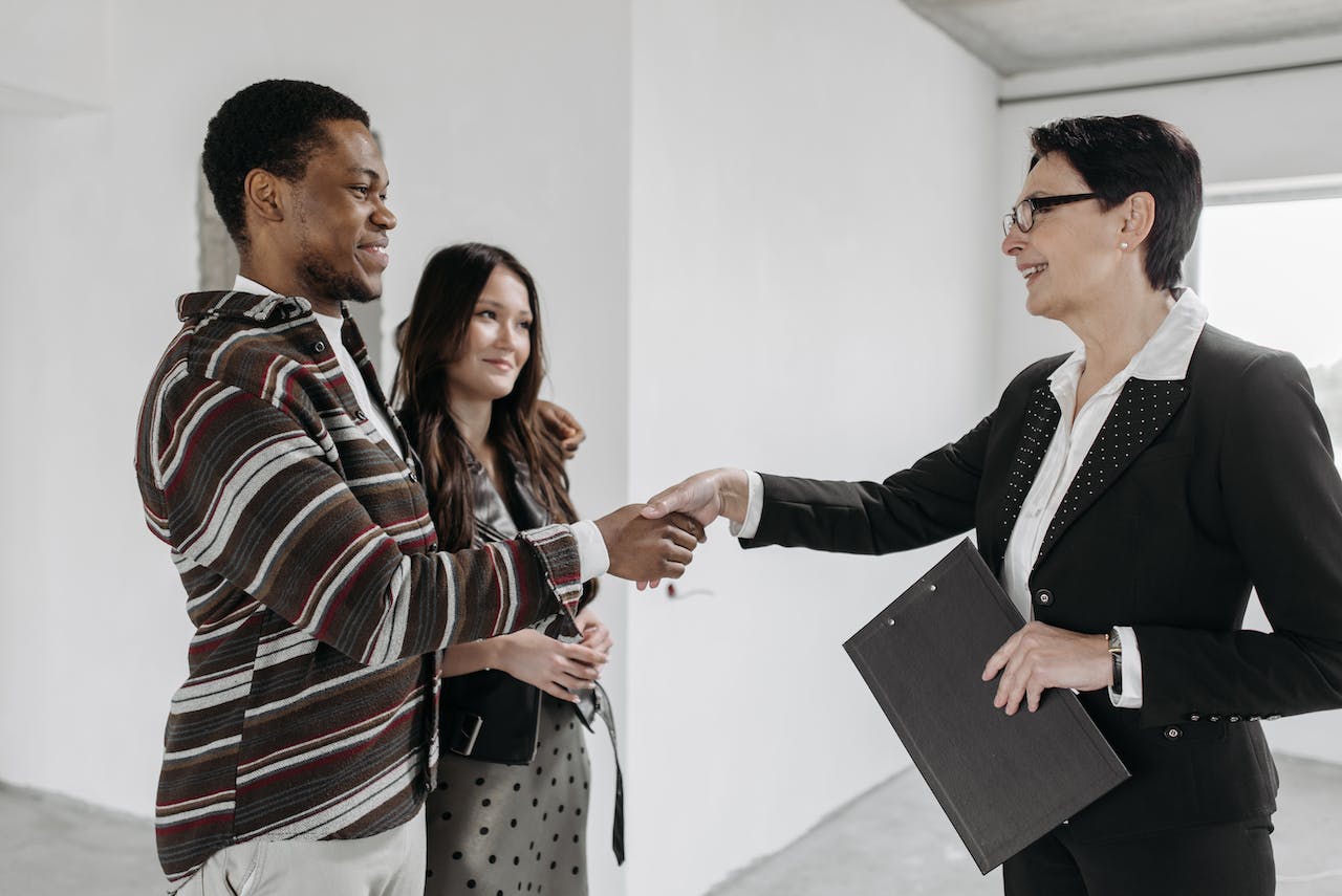 A Female Realtor Shaking Hands with Her Client